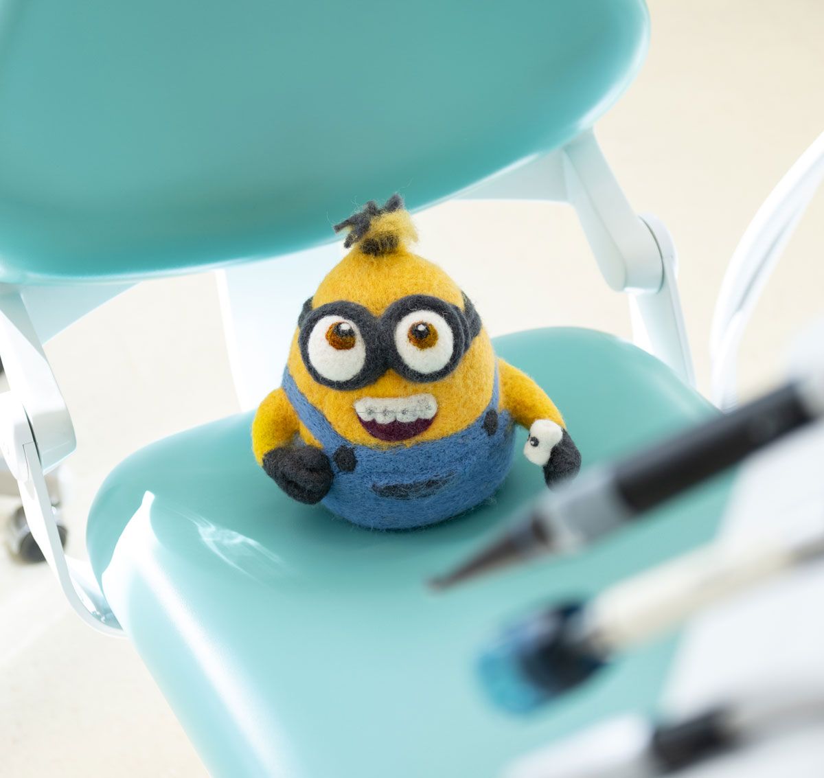 Minion-Figur auf einem türkisfarbenen Stuhl